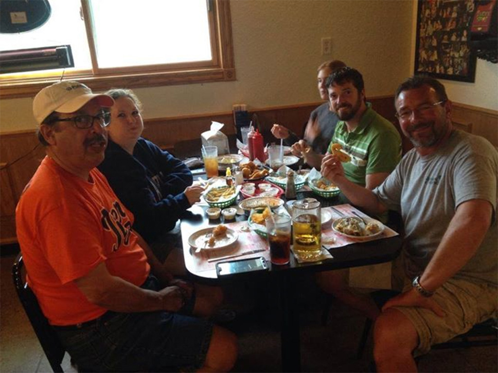 Captain Jeff Godi with fellow fishermen eating their spoils after a great charter trip on the Saginaw Bay with Michigan Experience Charters.